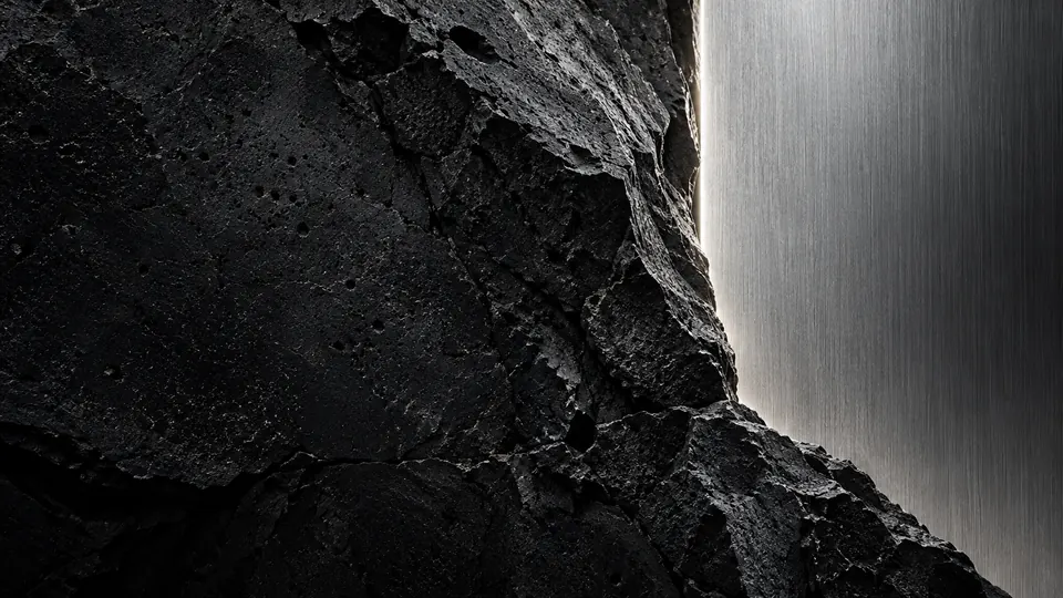 Fractured basalt against a brushed steel wall